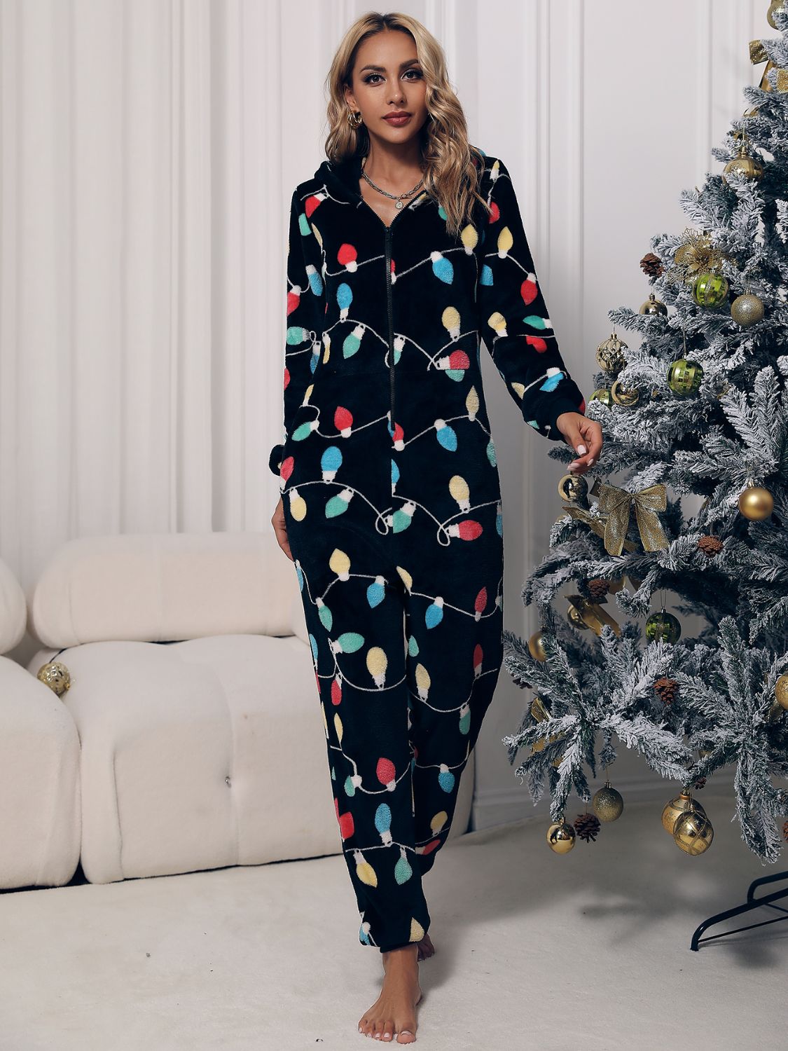 Festive lounge jumpsuit featuring holiday lights on soft fleece fabric
