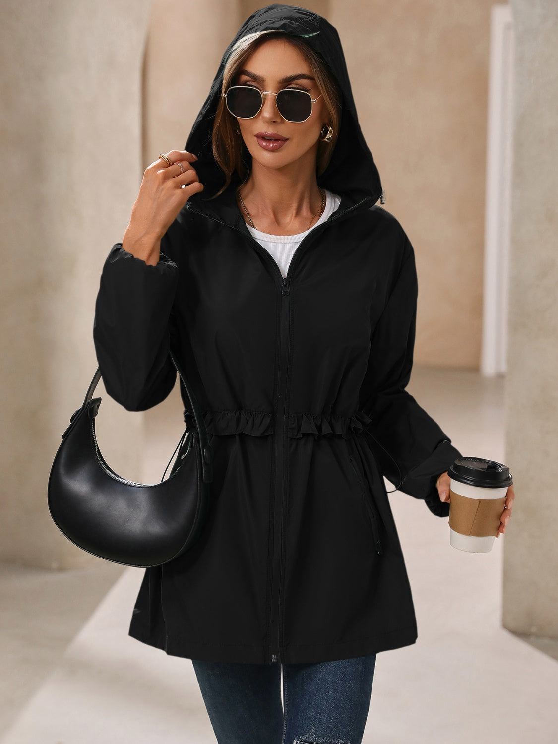 Stylish black womens rain jacket with waterproof fabric and an adjustable hood.
