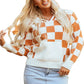 Orange and white checkered sweater with a hood, featuring a front pocket and long sleeves.
