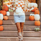 Orange and white checkered sweater with a hood, featuring a front pocket and long sleeves.
