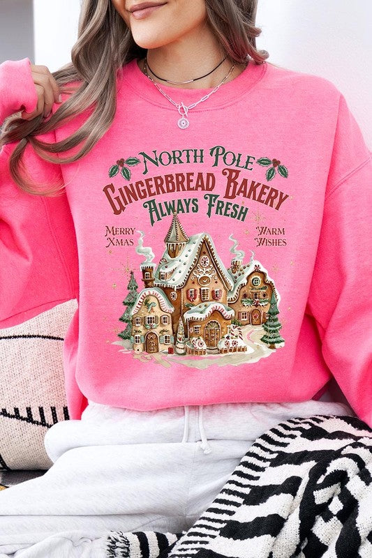 Bright hot pink sweatshirt with gingerbread house design, adding holiday cheer.