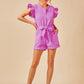 Pink jean romper featuring ruffled sleeves and waist tie