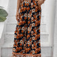 Woman in bohemian floral wide-leg pants, perfect for casual and beach outings.