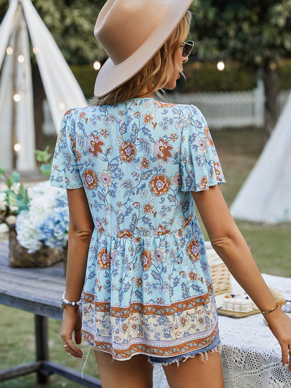 Woman styling a light blue floral peplum top with orange details, perfect for casual outings.