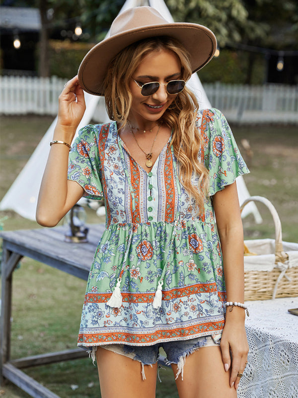 Boho chic floral print peplum top in green and orange, paired with distressed denim shorts.