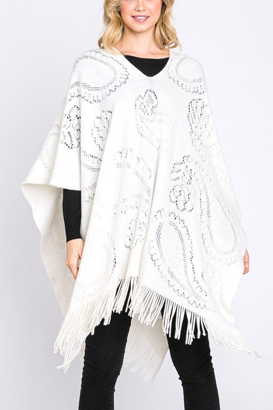 Ivory paisley perforated knit poncho with fringe hem, front view.
