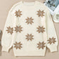 Flat-lay of an ivory knit sweater featuring a snowflake design, ideal for a cozy holiday look.