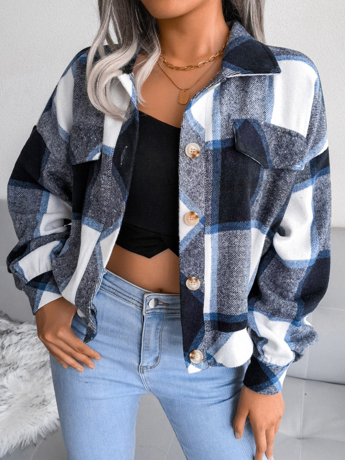 Women’s navy plaid collared jacket with button closure, perfect for layering.
