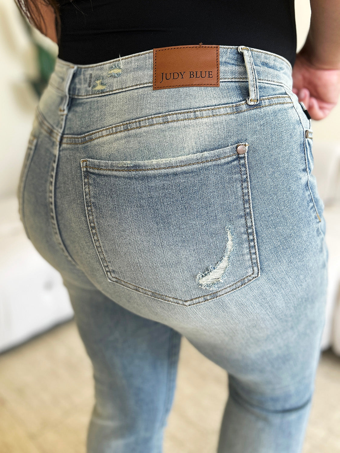 Close-up of the Judy Blue label on the back of mid-rise flare jeans.