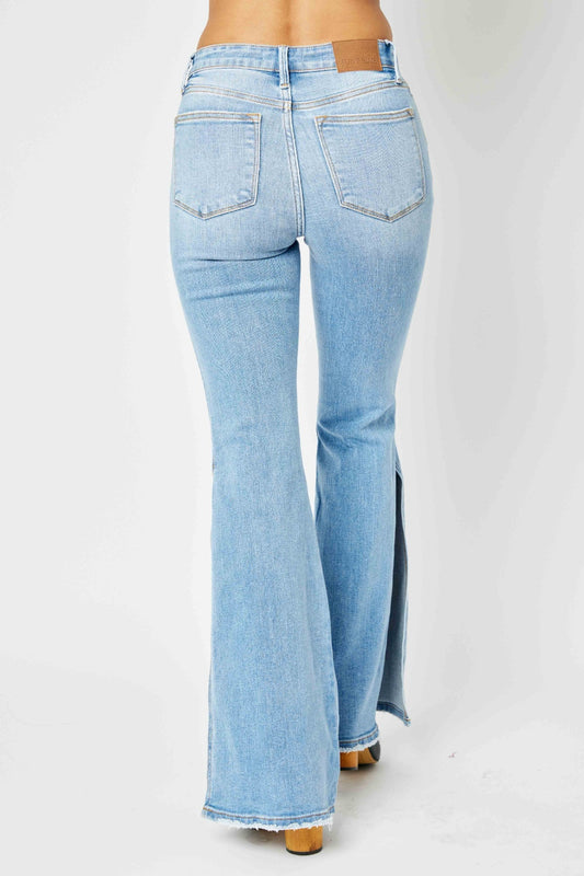 Back view of Judy Blue mid-rise raw hem slit leg flare jeans in light wash.