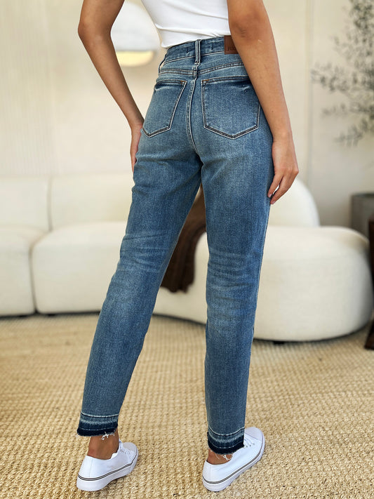 Judy Blue Mid Rise Rigid Magic Release Hem Jeans worn by a model.