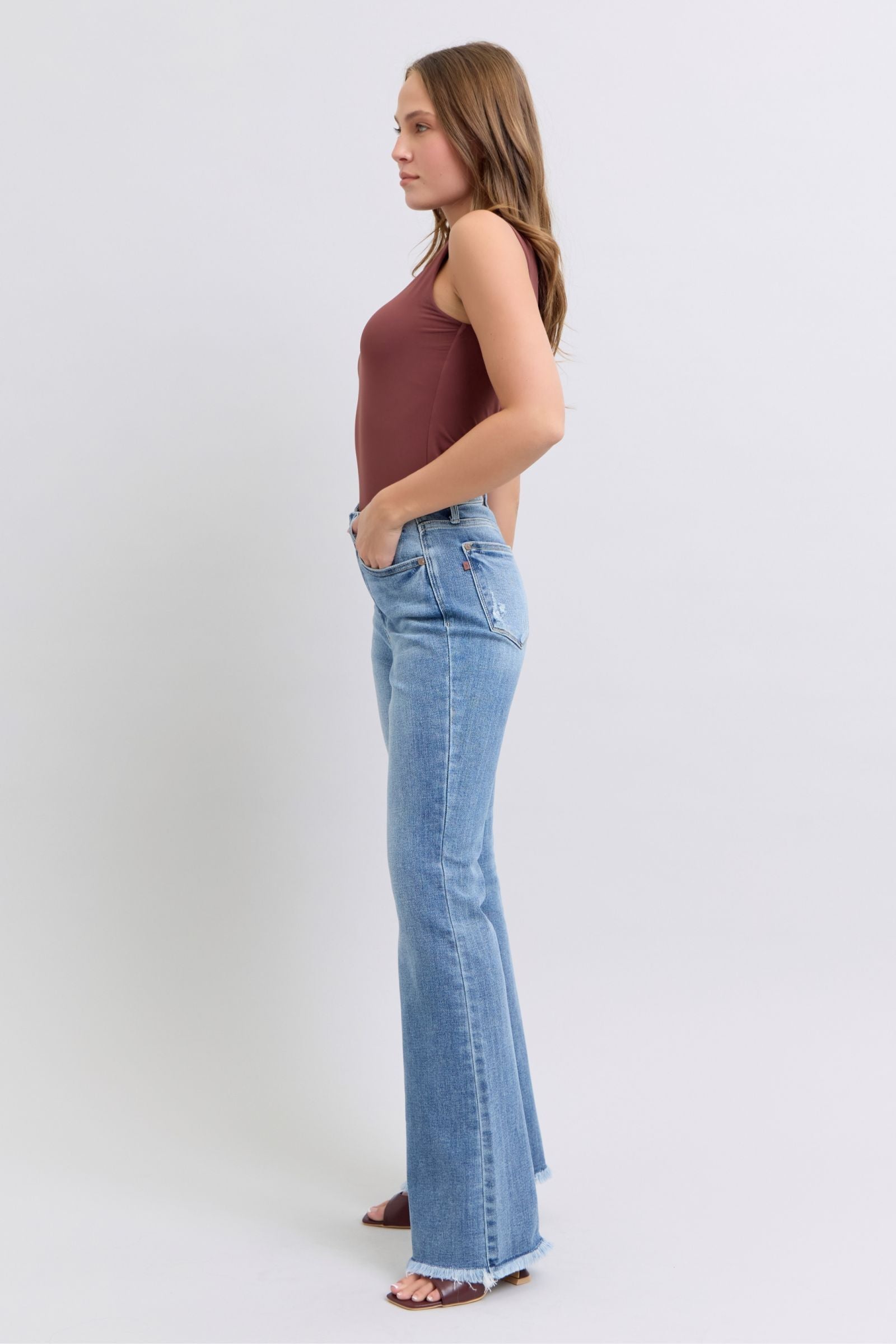 Side view of Judy Blue Raw Hem High Rise Bootcut Jeans highlighting the bootcut silhouette and raw hem detail.
