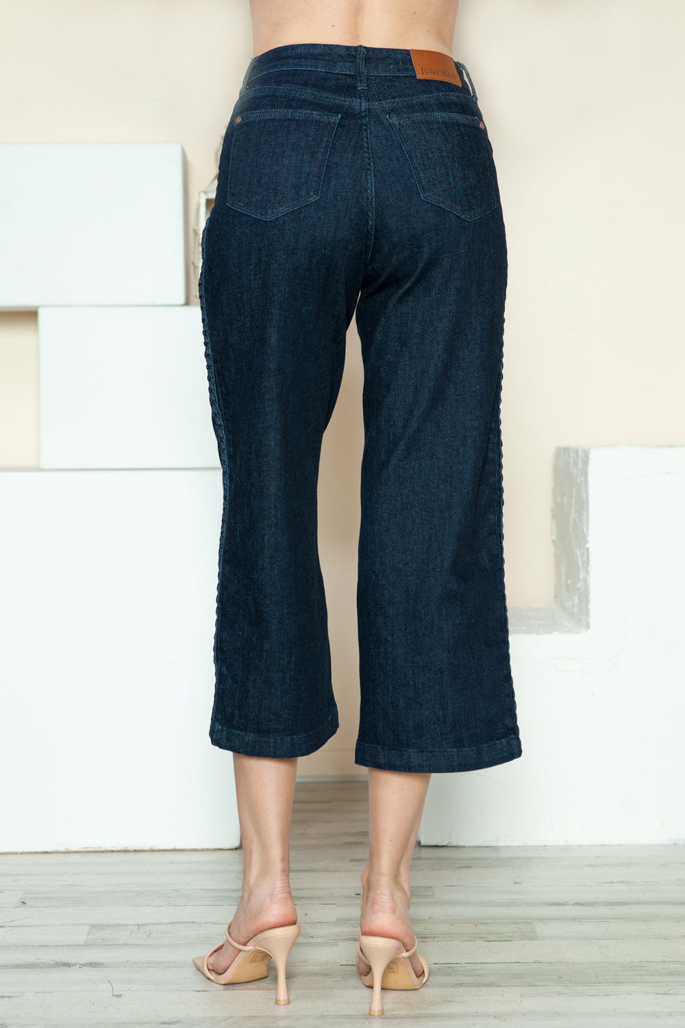 Wide-leg Judy Blue jeans styled with neutral heels for a chic look.
