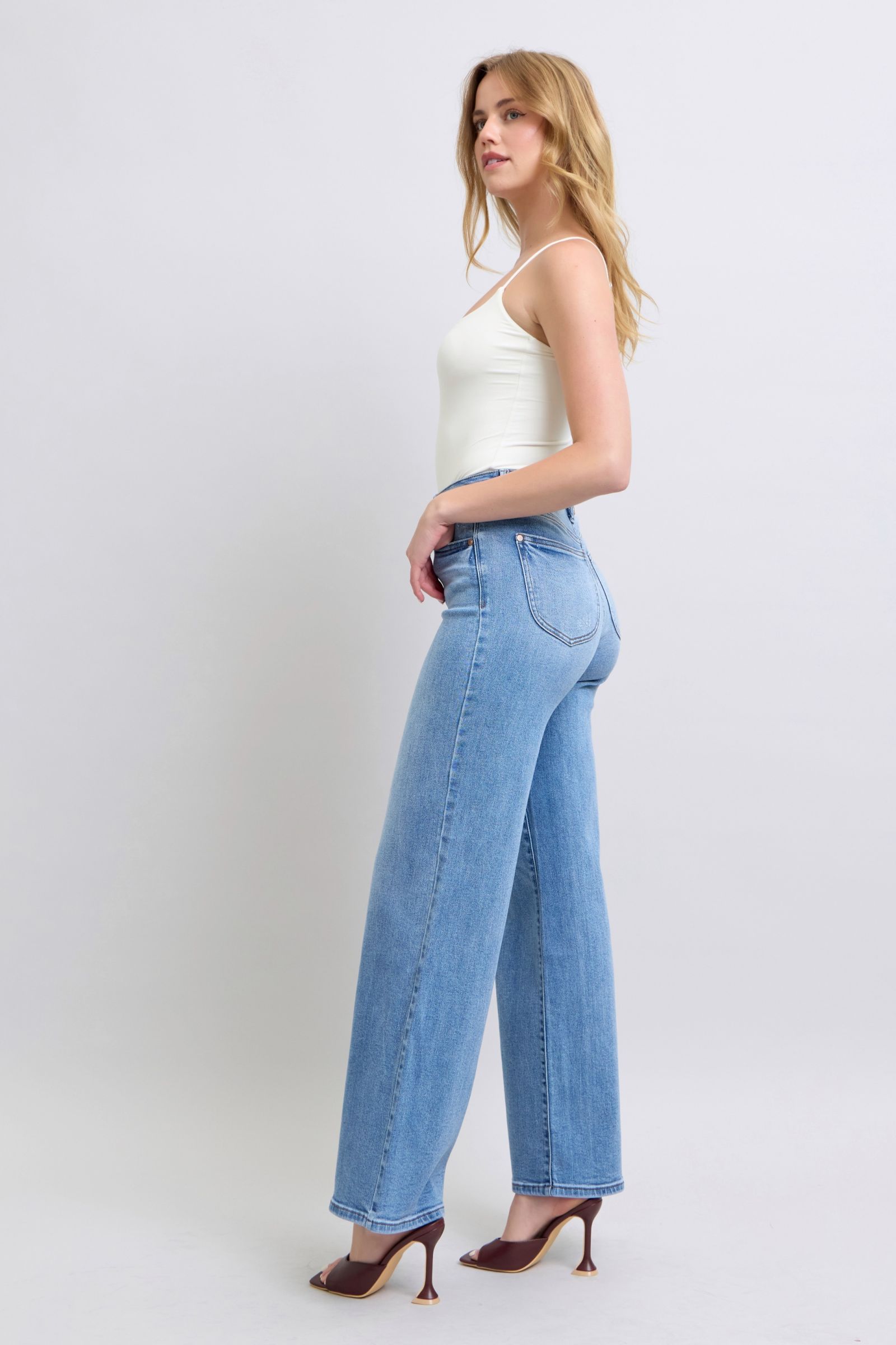 Judy Blue wide leg jeans styled on a model walking to highlight the flow of the wide-leg silhouette.
