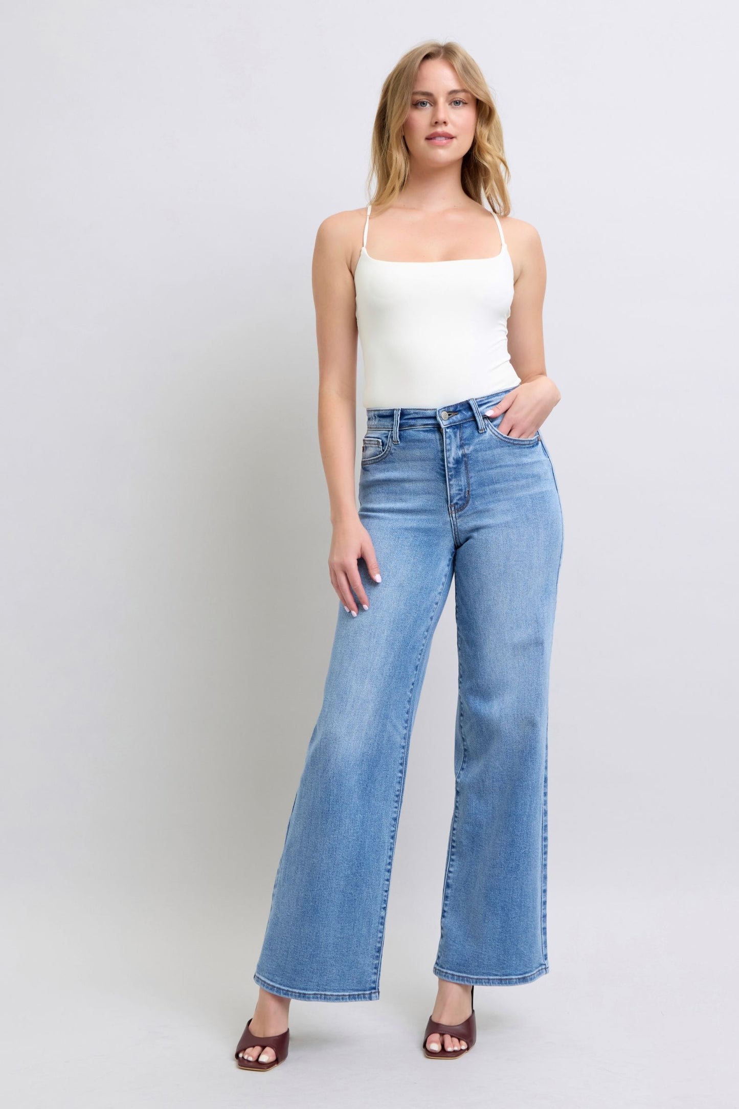 Styled outfit featuring Judy Blue wide leg jeans paired with a white crop top and sandals.
