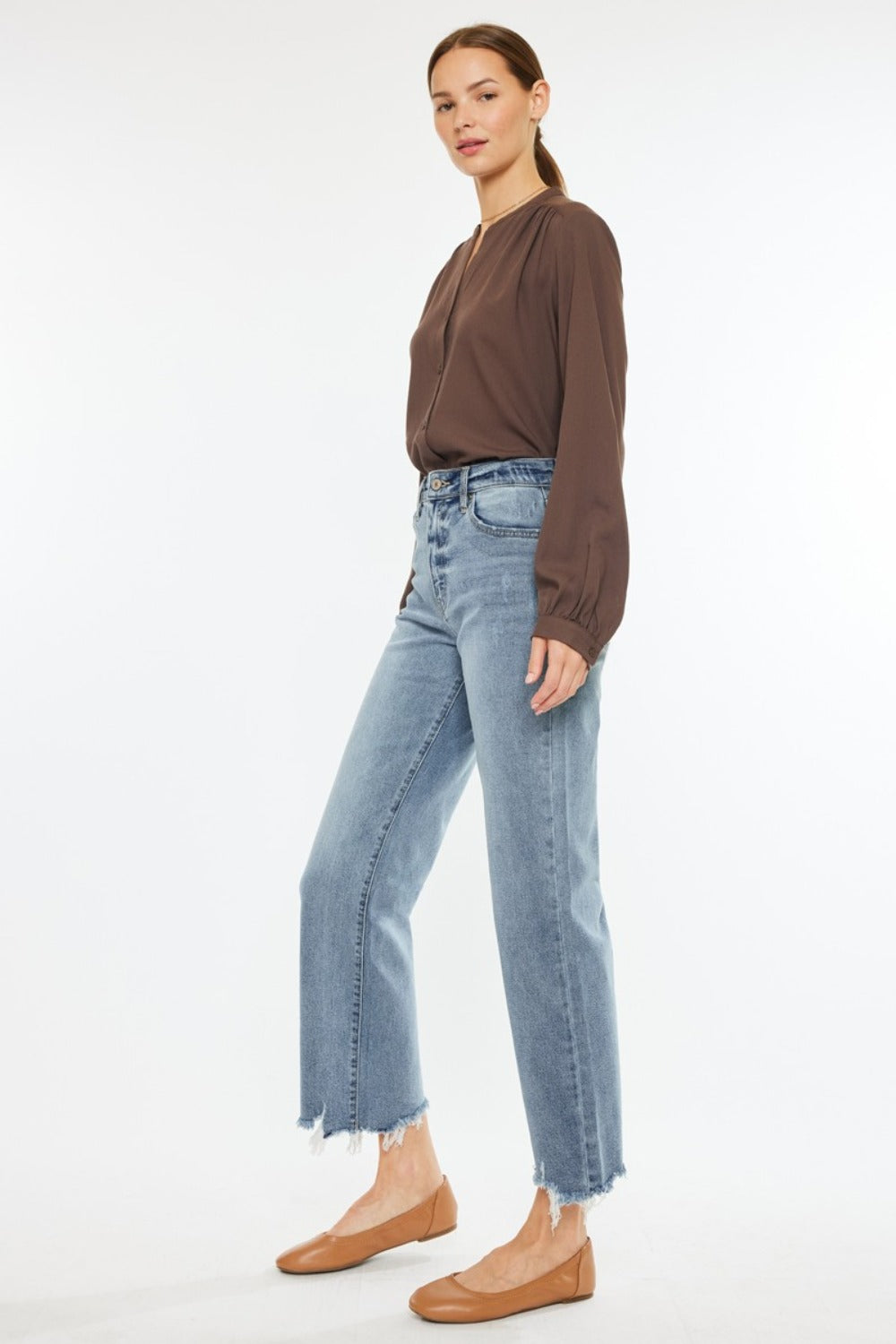 Back view of Kancan high-rise slim wide leg jeans in light wash with a raw hem.
