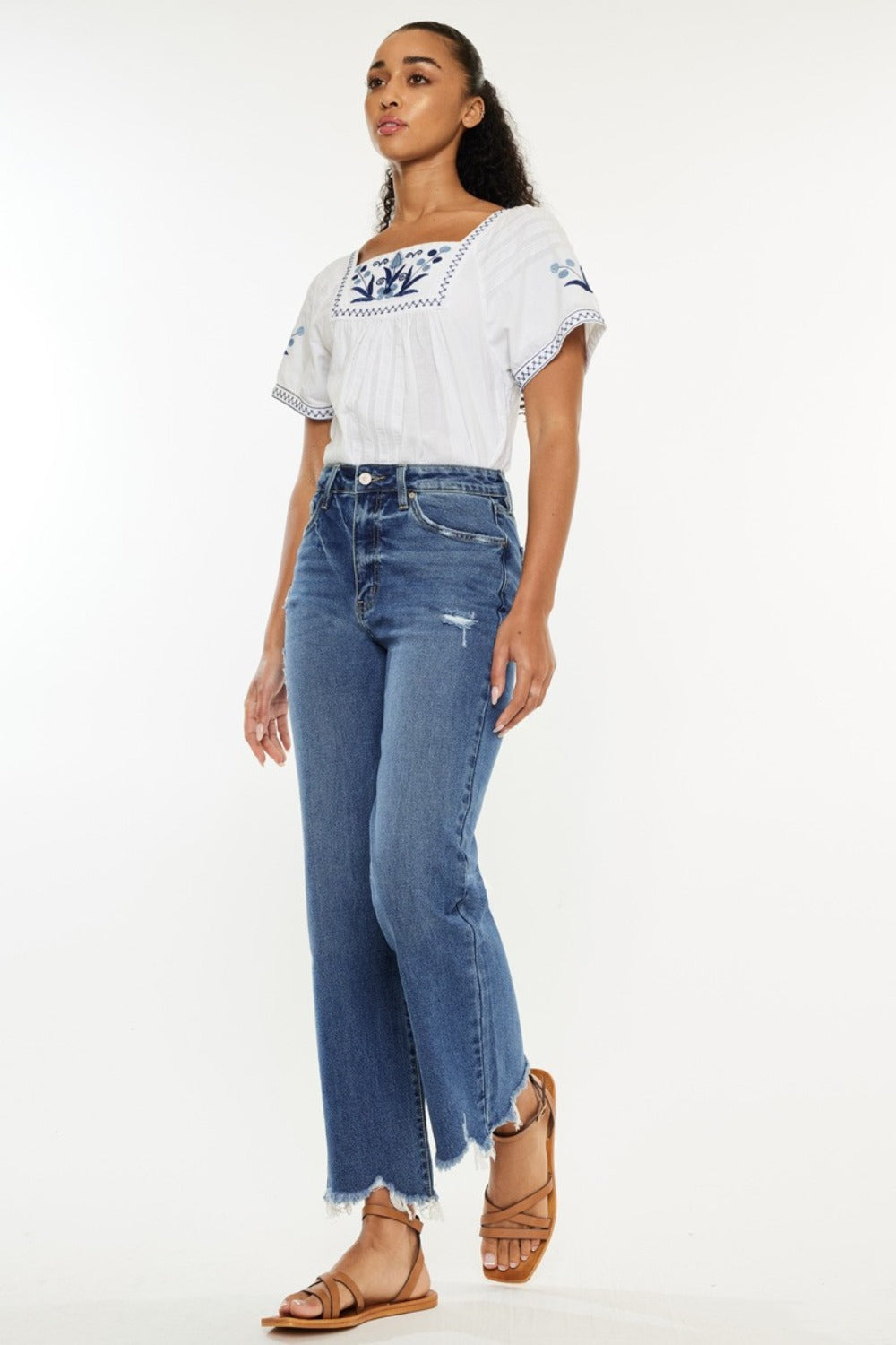 Women's high-rise Kancan jeans with a slim wide leg cut and distressed hem detail.
