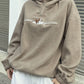 Woman wearing a khaki "Climbing Mountain" fleece pullover.
