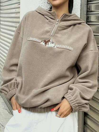 Khaki pullover with mountain graphic, adding an outdoor touch.
