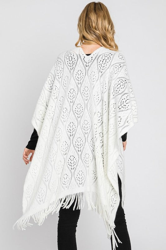 Fringe detailing on the ivory knitted poncho.