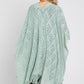 Fringe detailing on the mint green knitted poncho.