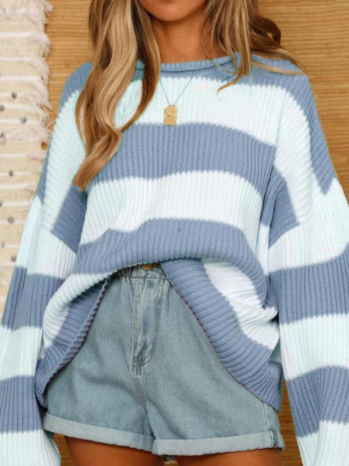 Woman wearing a light blue and white striped ribbed sweater.
