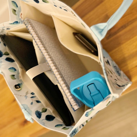 Inside zippered pocket of blue floral tote for secure storage of small items.
