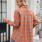 Casual orange plaid button-up shirt tied at the waist for a trendy look.
