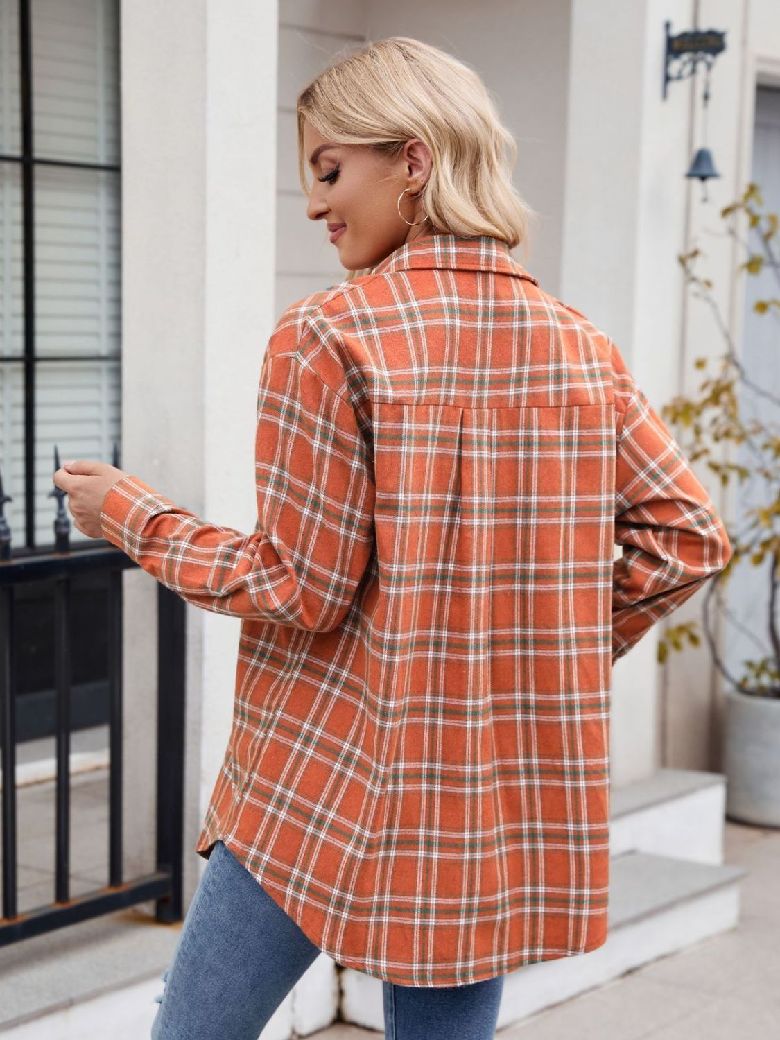 Casual orange plaid button-up shirt tied at the waist for a trendy look.
