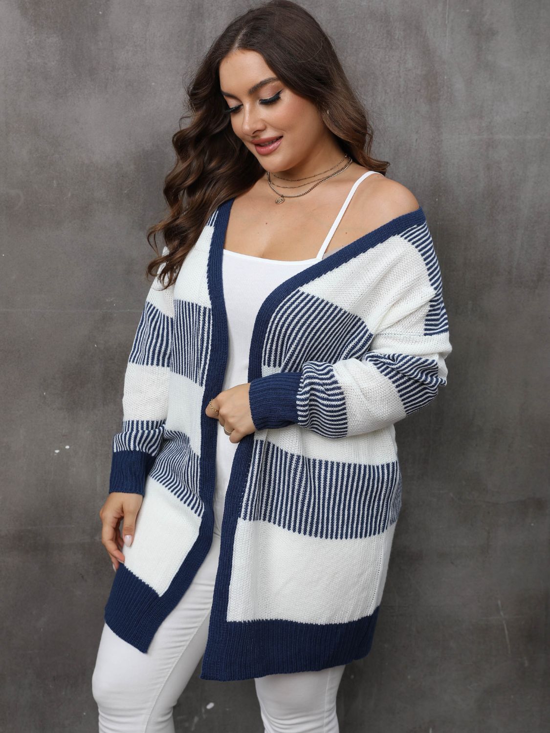 Comfortable and cozy plus-size navy and white cardigan, styled with white pants.
