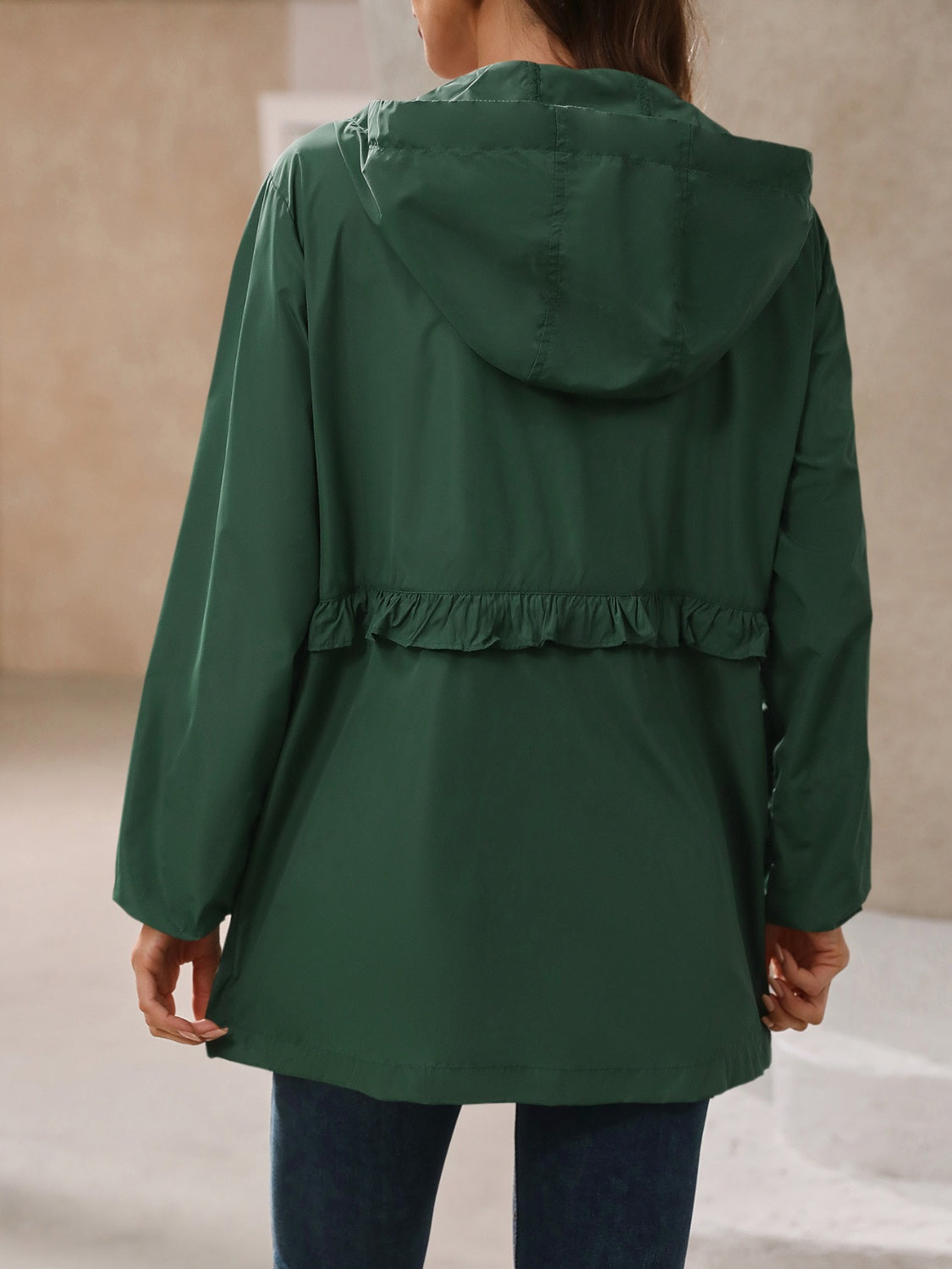 Green womens rain jacket, designed for rainy days with its waterproof and lightweight material.
