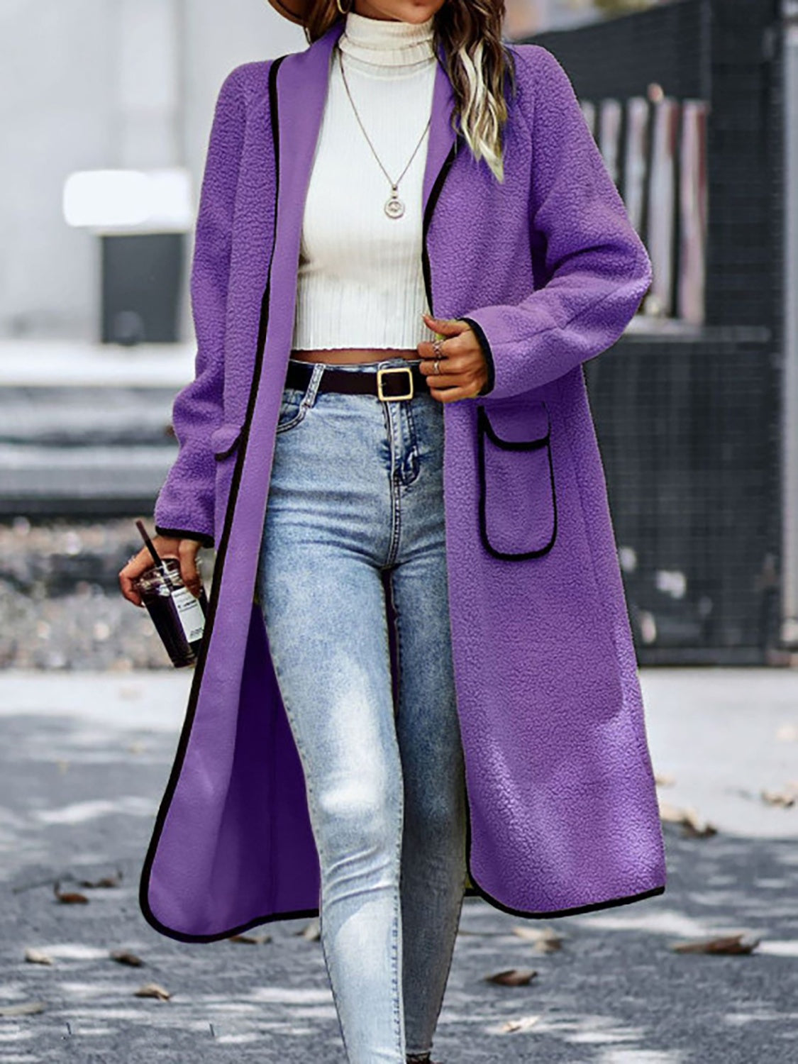 Elegant long sherpa coat in purple with stylish contrast trim.
