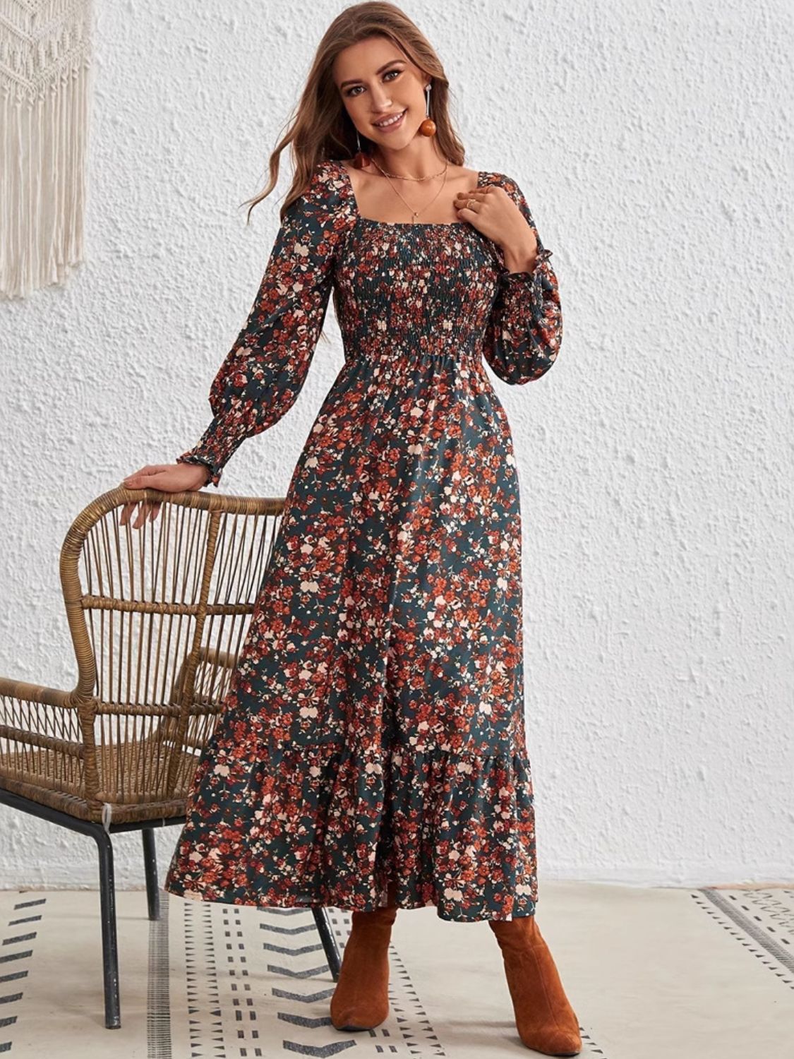 Woman wearing boho-inspired long sleeve floral dress paired with knee-high boots.
