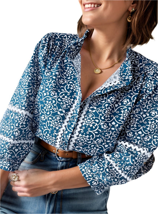 Woman wearing a long sleeve mock neck blouse with a blue and white pattern
