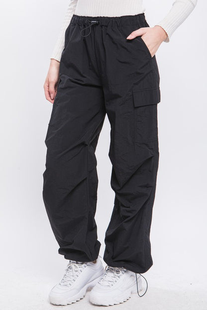 Front view of loose-fit cargo pants in black with adjustable elastic waist.
