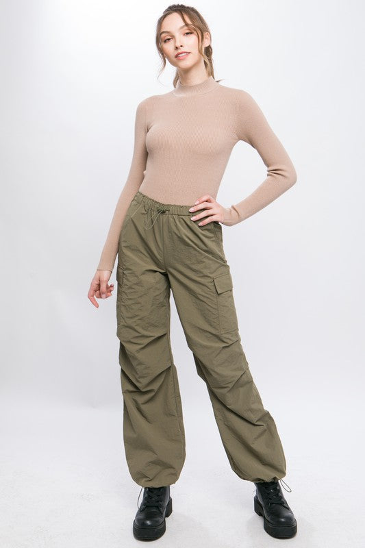 Front view of loose-fit cargo pants in olive with adjustable elastic waist.
