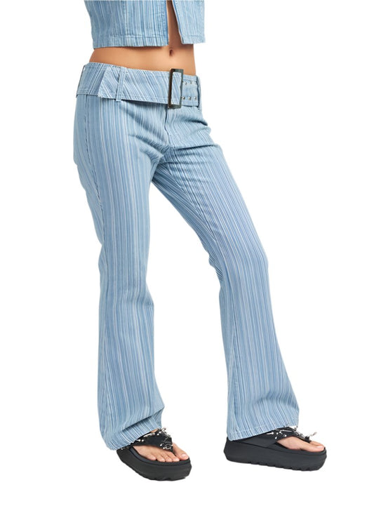 Woman wearing light blue low-rise flared jeans with a statement belt.