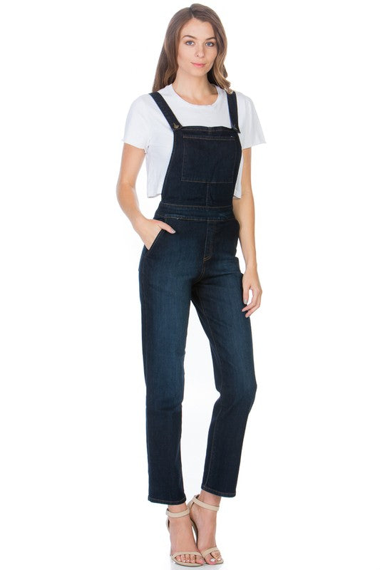 Casual outfit styled with dark wash denim overalls and a white tee.
