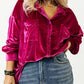 Vibrant magenta velvet button-down shirt with functional chest pockets.
