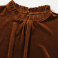 Mocha velvet frill neck top captured in natural light, highlighting its rich texture.





