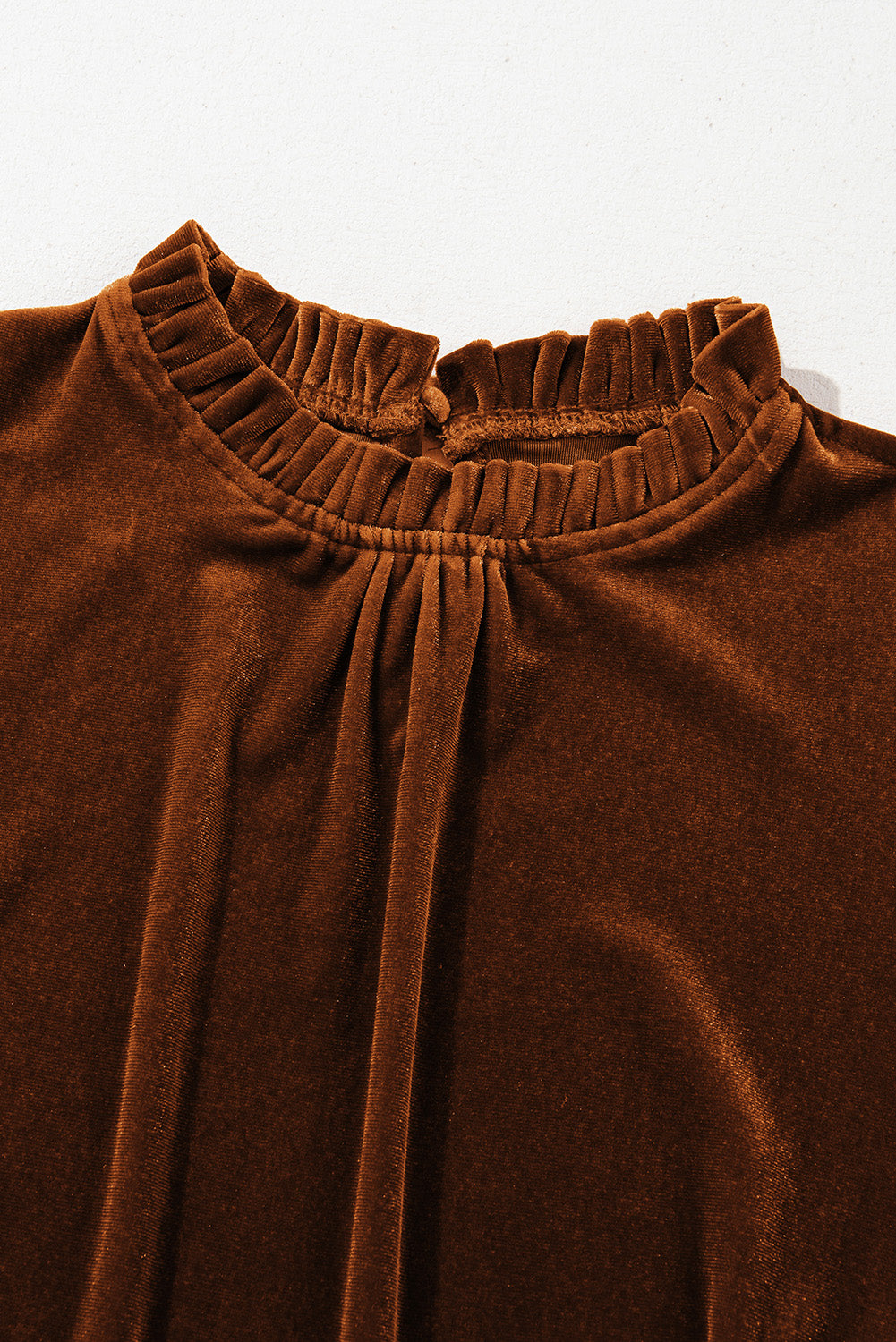 Mocha velvet frill neck top captured in natural light, highlighting its rich texture.





