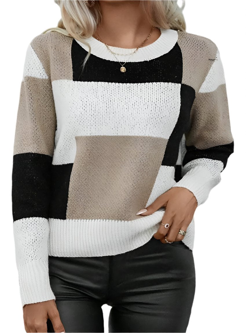 Woman wearing a modern color block knit sweater in black, beige, and white.
