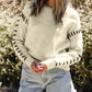 Soft beige sweater with bold stitch design along each sleeve.
