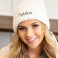 Stylish cream beanie with black Mama text and matching pom

