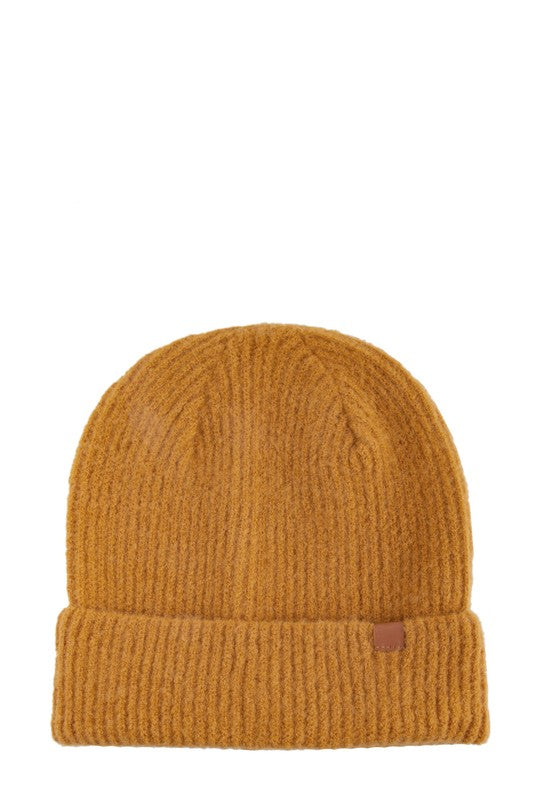 A mustard knit beanie with a leather tab, designed for both warmth and style.
