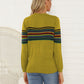 Woman wearing a trendy mustard yellow and striped knit sweater for fall
