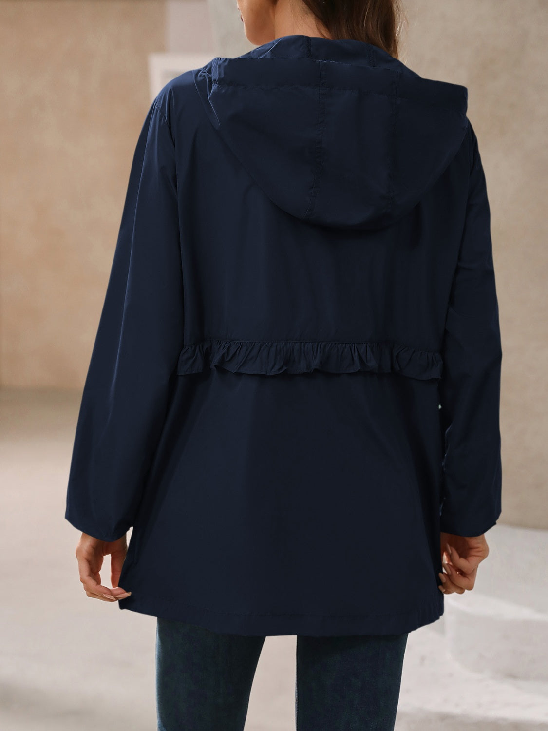 Navy womens rain jacket with a hood, made from waterproof material for wet weather.
