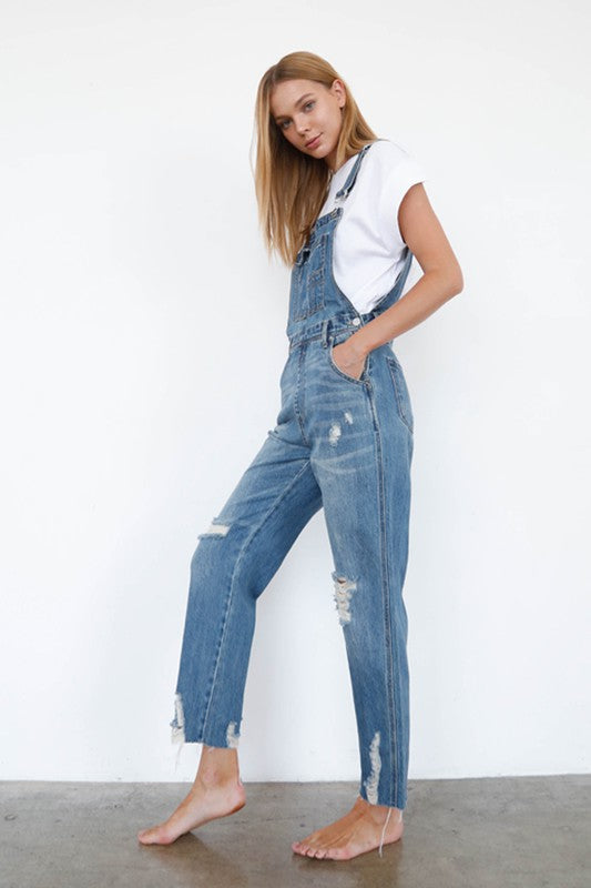 Relaxed-fit slim straight denim overalls with side button closure for women.
