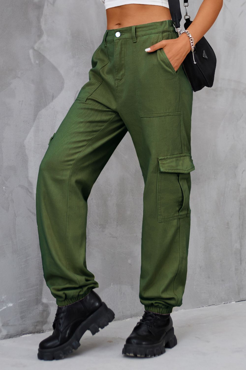 Side profile of olive high-waist cargo pants with functional pockets.
