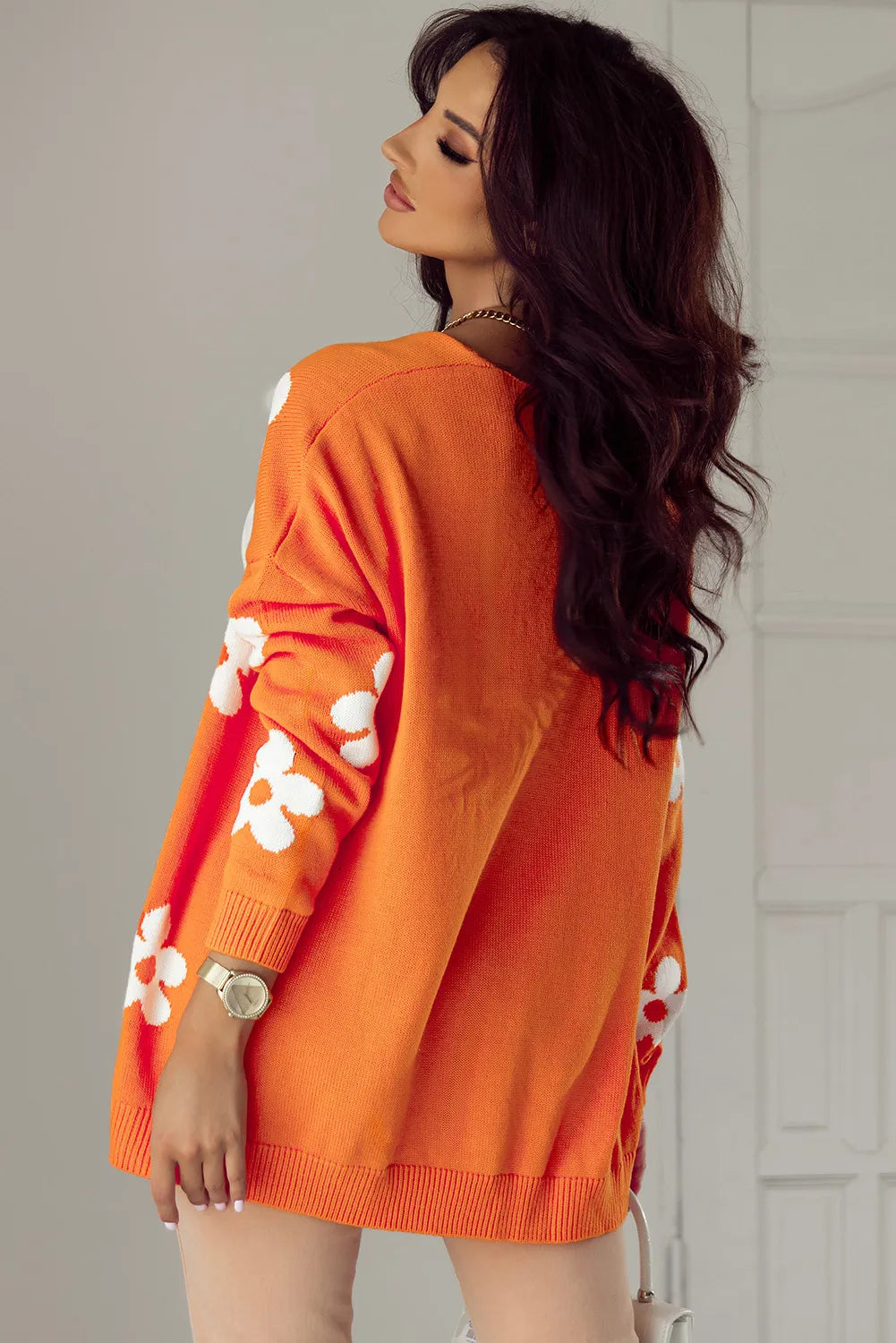 Side view of orange floral cardigan with relaxed fit